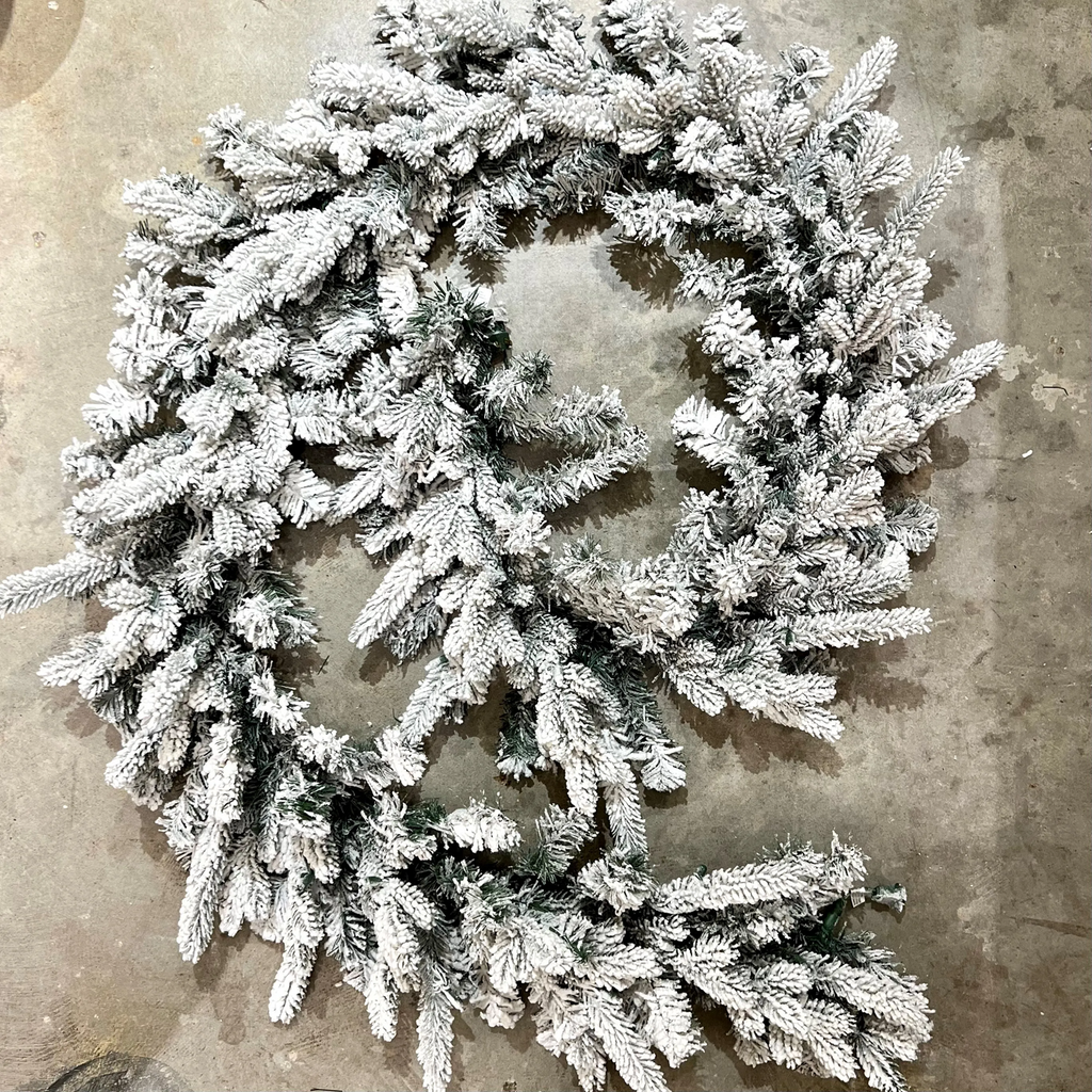 Flocked Christmas garland on a concrete surface